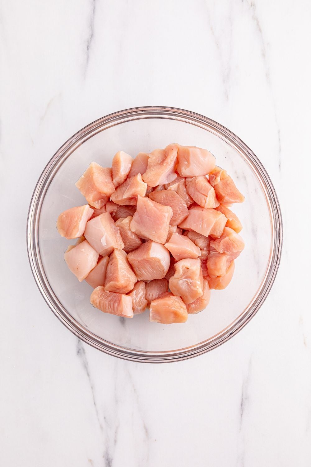 raw chicken cubed up in a bowl for making Better Than Takeout Kung Pao Chicken