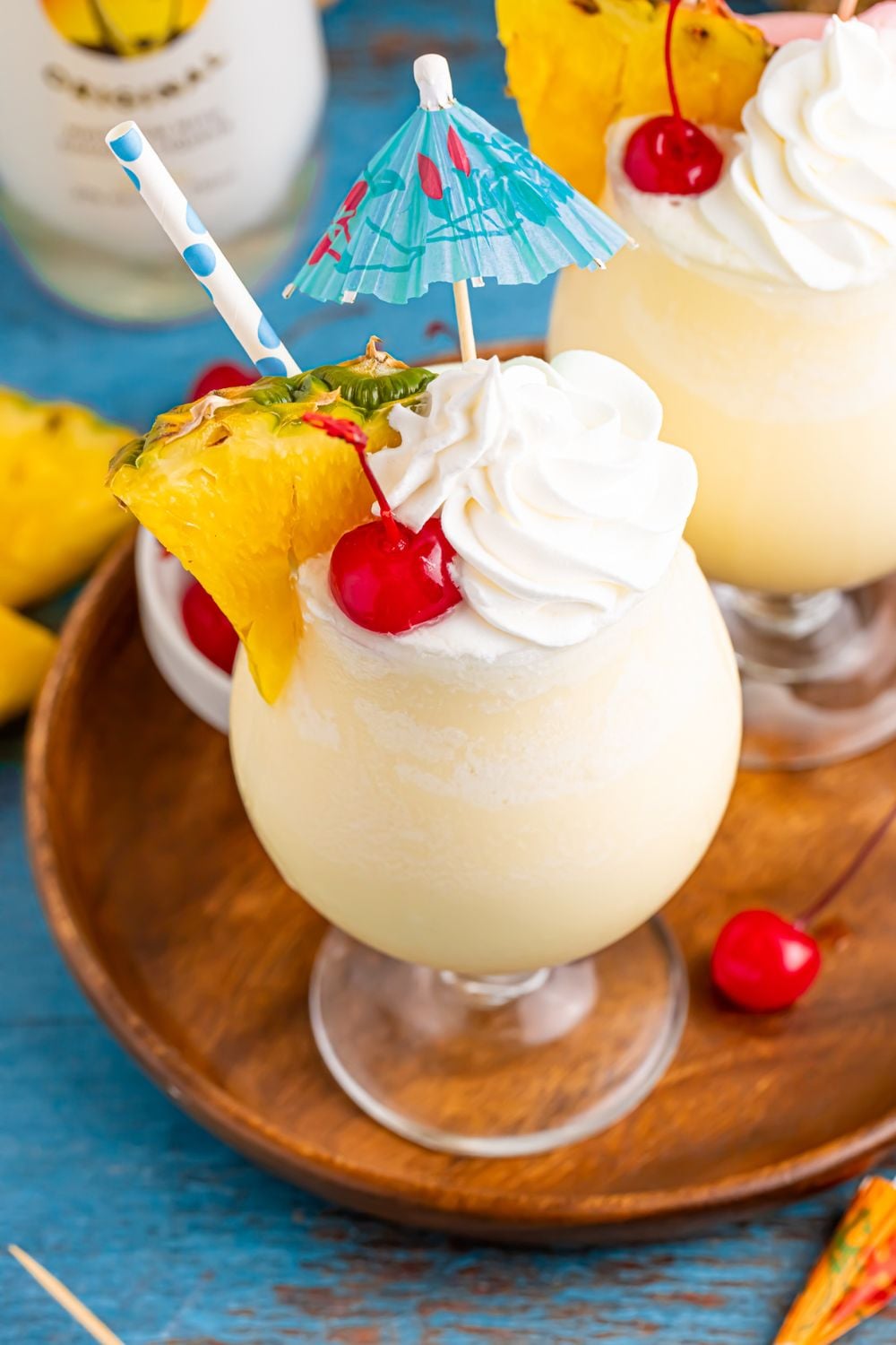 Frozen Malibu Piña Colada on table with pineapple wedge and umbrella