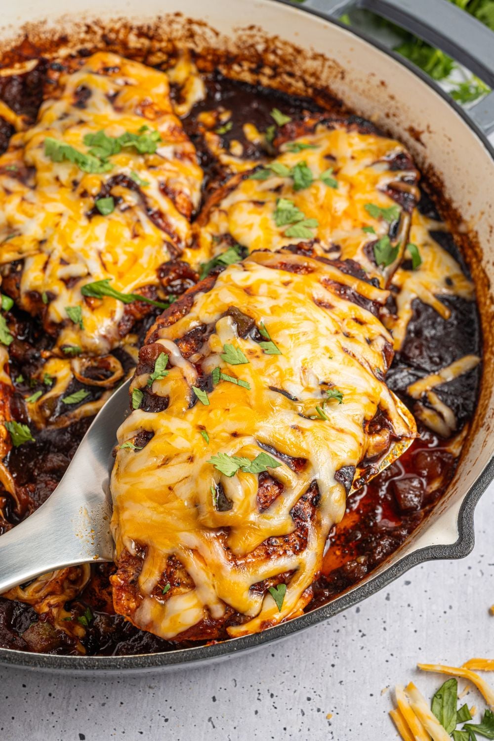 Cheesy Salsa Chicken being lifted out of a pan 