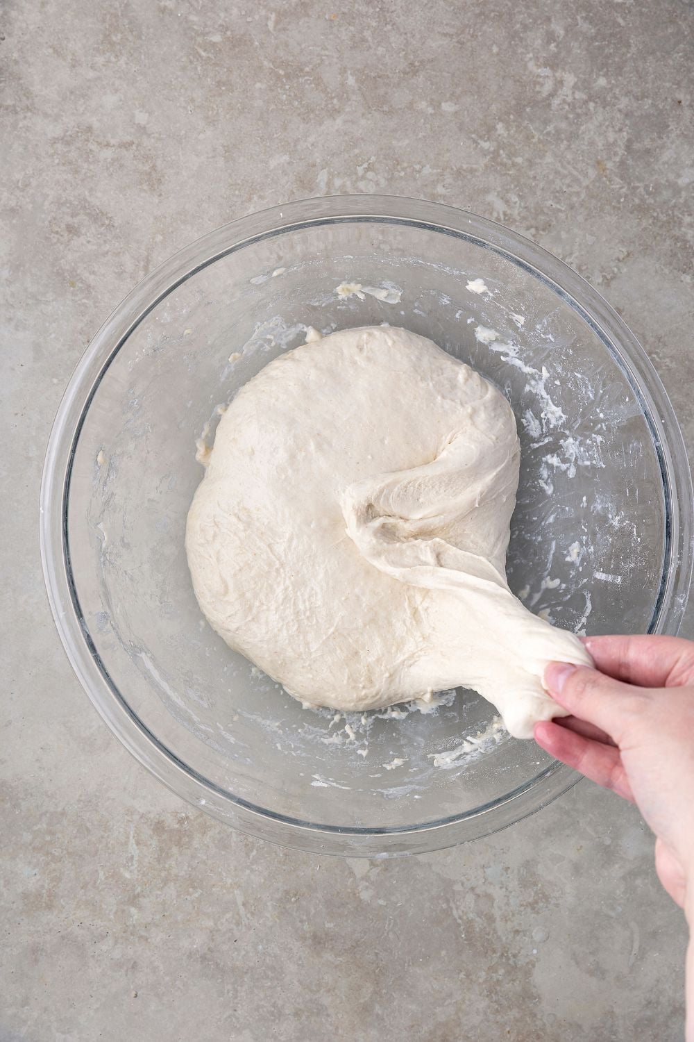pulling the Homemade Sourdough Bread dough to show texture