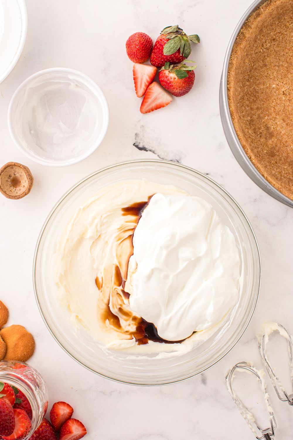 ingredients to make a No Bake Strawberry Cheesecake in a bowl on table