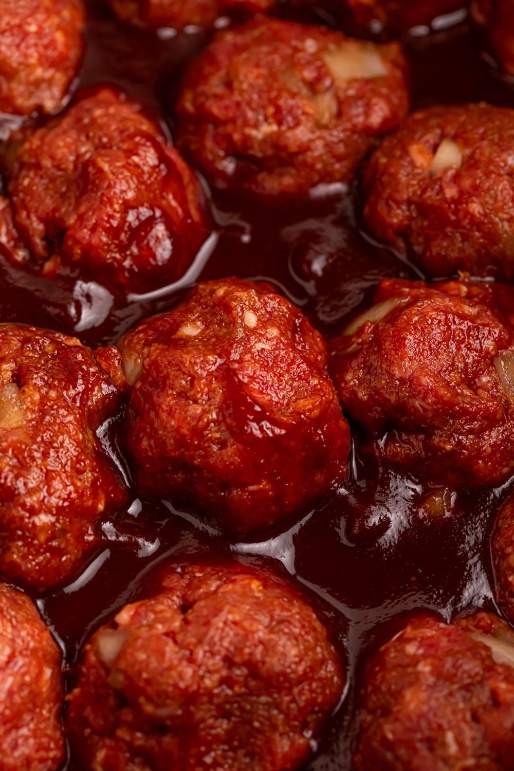 close up of meatballs in a bbq sauce being cooked in a CrockPot