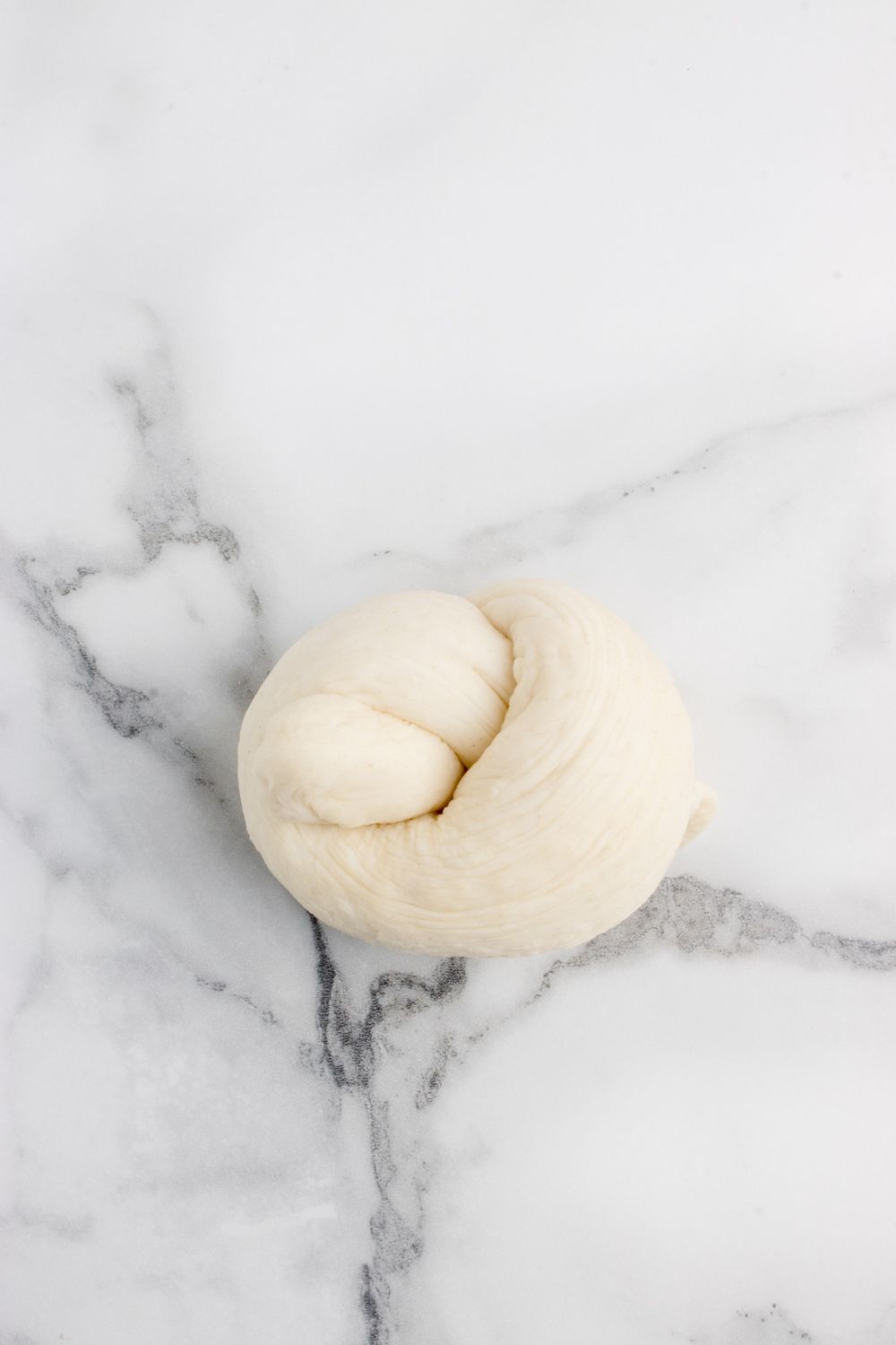 rolling dough into a knot sitting on table 
