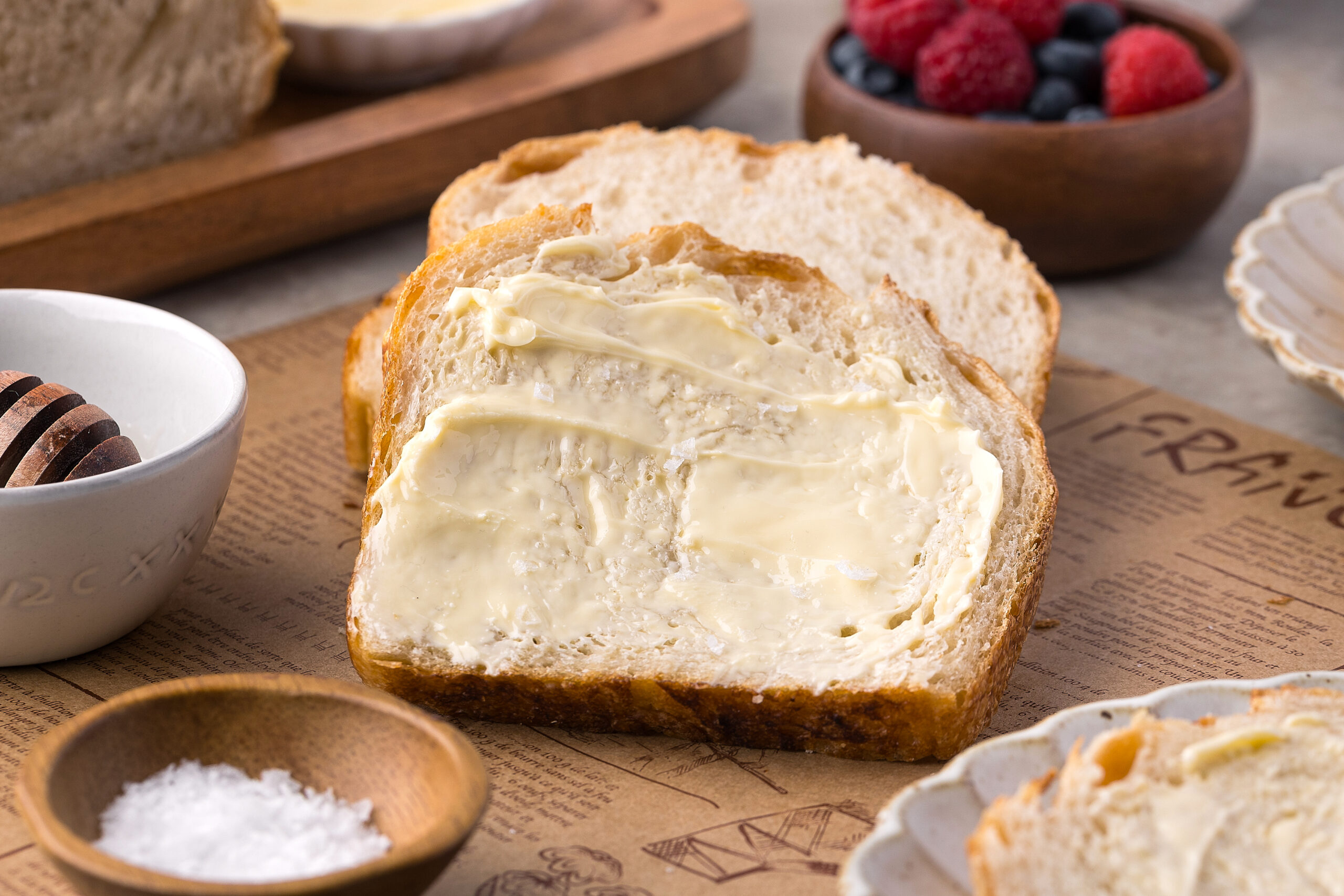 Homemade Sourdough Bread sliced and buttered sitting on a table 