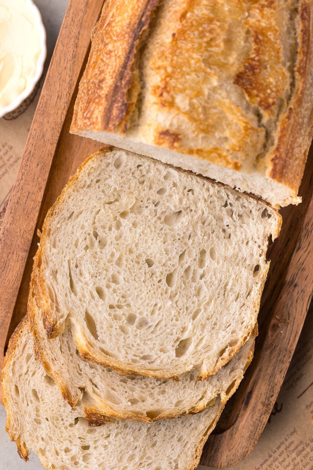Homemade Sourdough Bread on cutting board with half the loaf sliced in sandwich slices 
