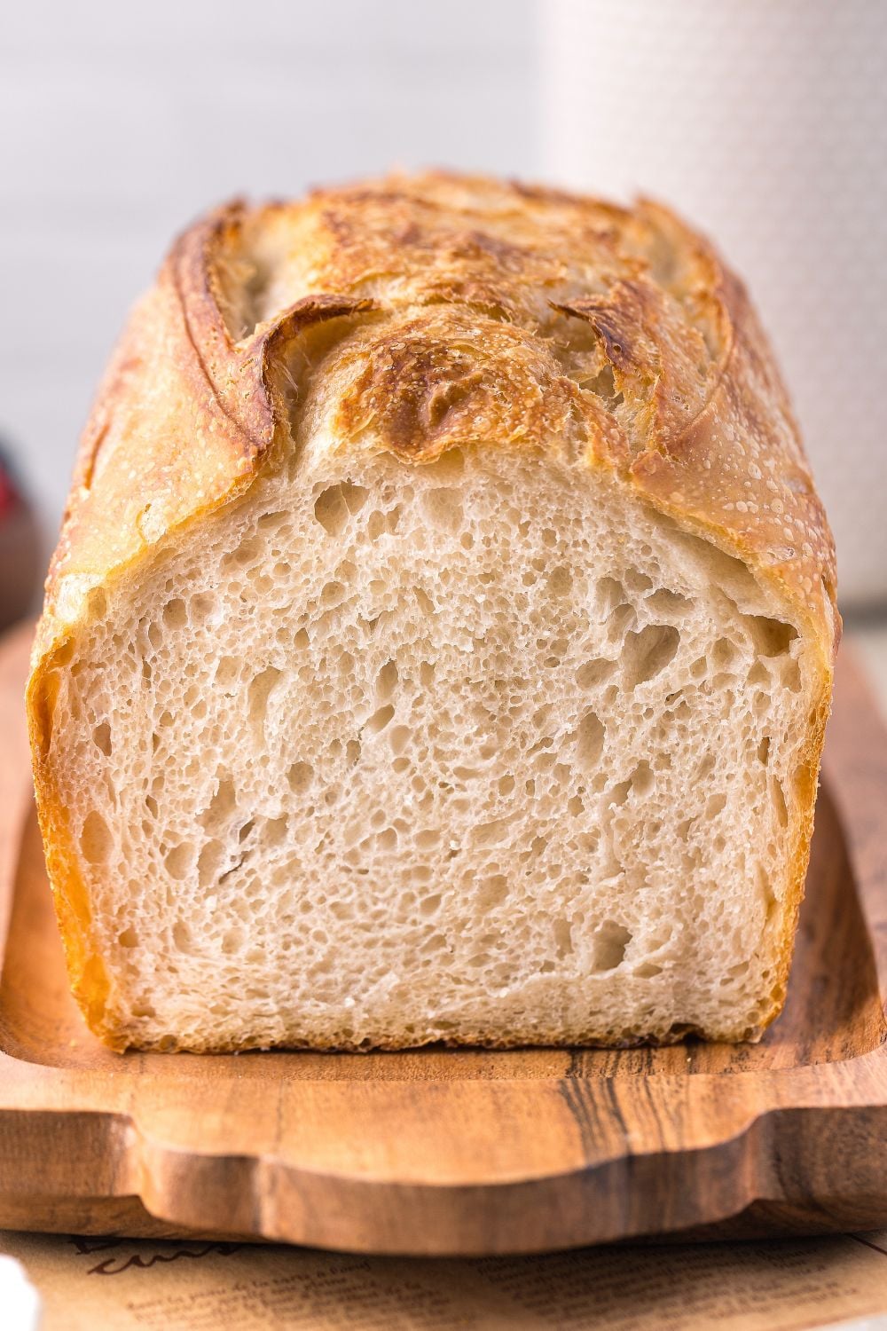 Homemade Sourdough Bread on a cutting board with some cut off to see the chewy center of bread 
