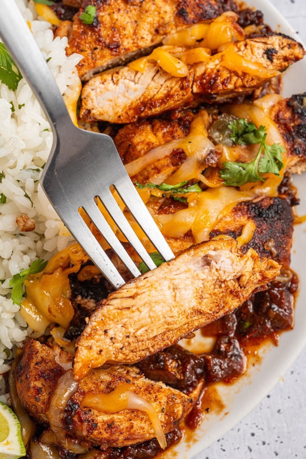 Cheesy Salsa Chicken on a fork and a bed of rice to the side 