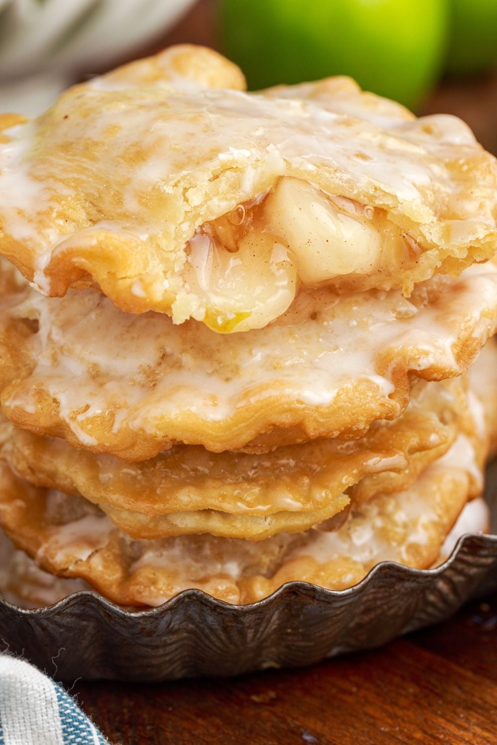 stack of Deep Fried Apple Hand Pies with top one with a bite taken out of it