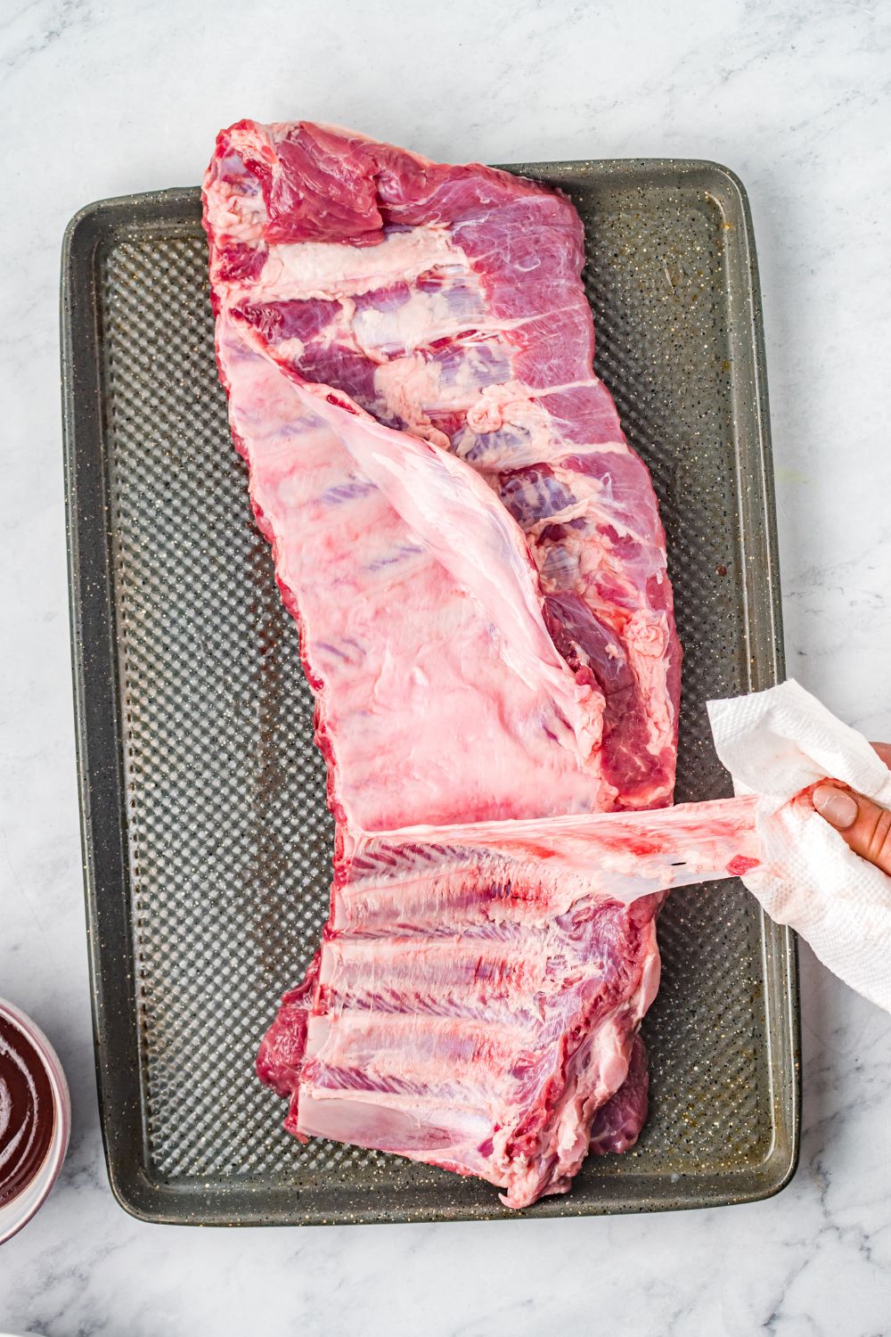 peeling silverskin off a slab of ribs