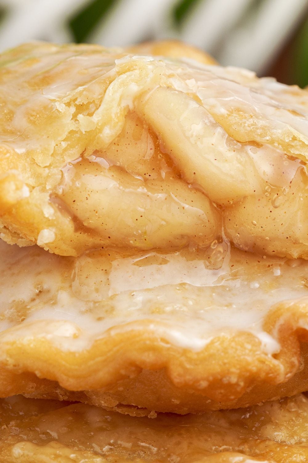 Deep Fried Apple Hand Pies stacked on top of each other with one that has a bite taken out of it