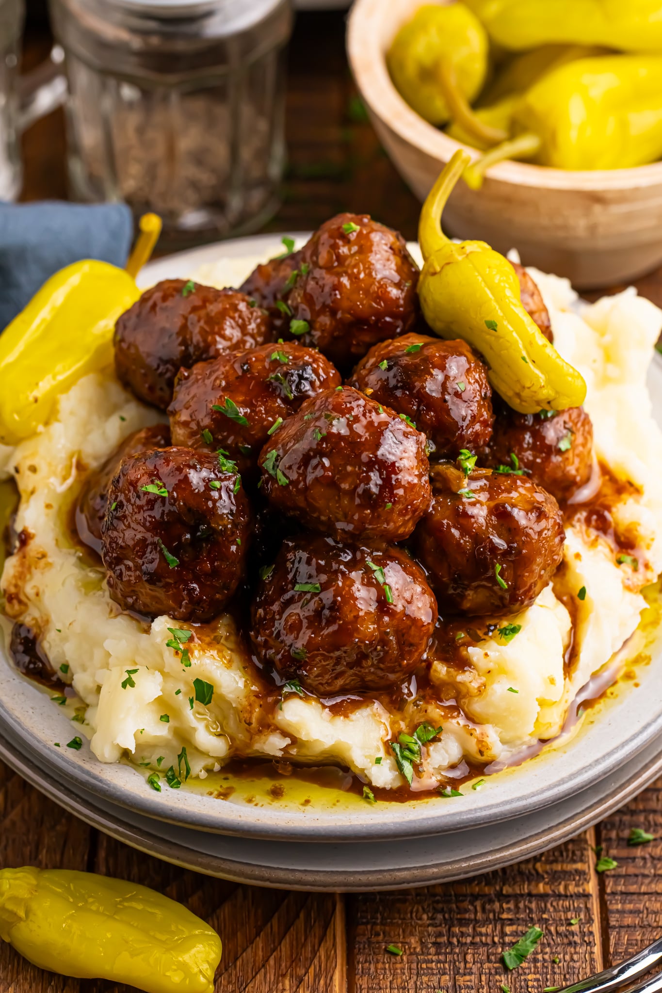 Crockpot Mississippi Meatballs on a plate with a bed of mashed potatoes underneath