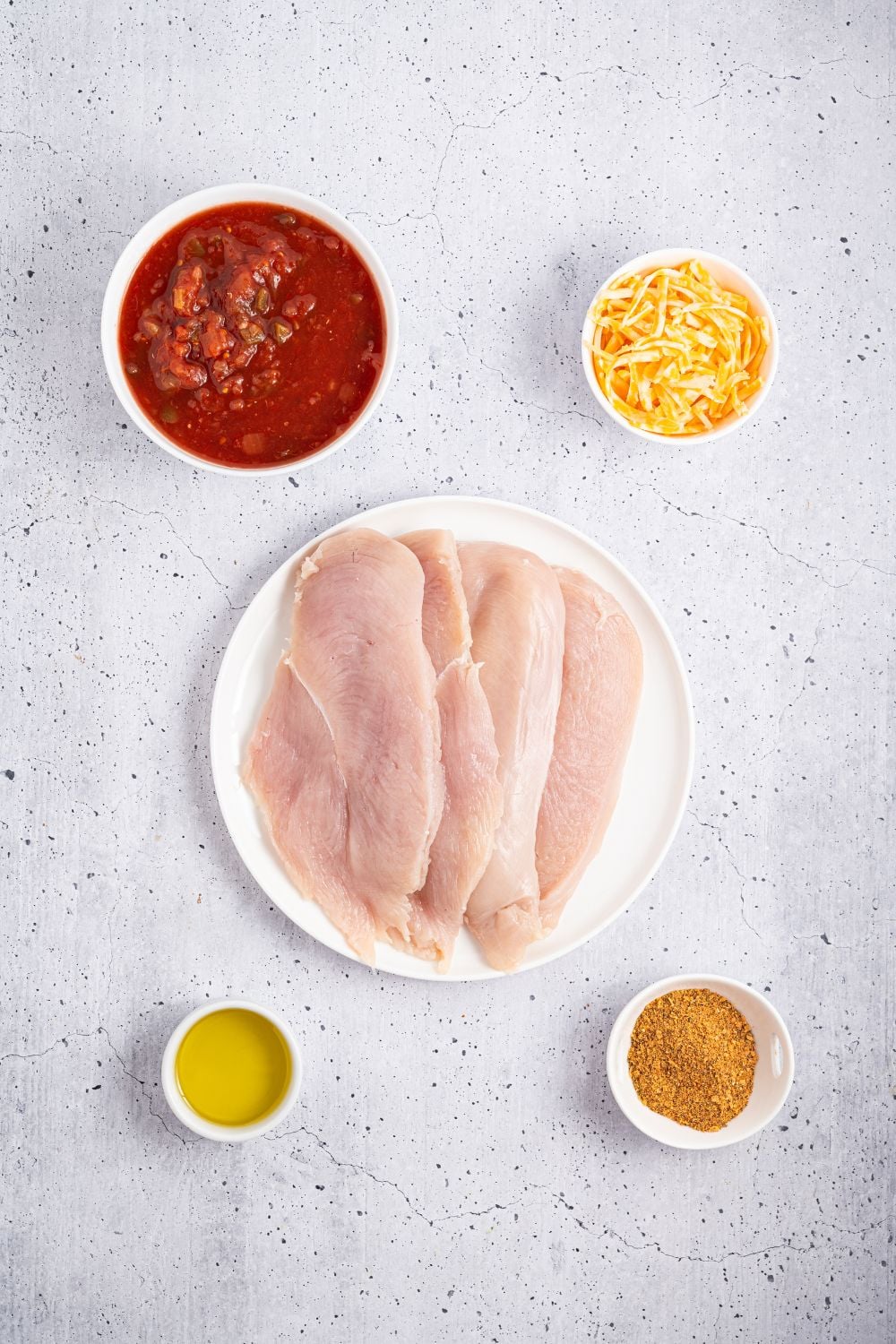 Cheesy Salsa Chicken ingredients on table in single serve bowls 
