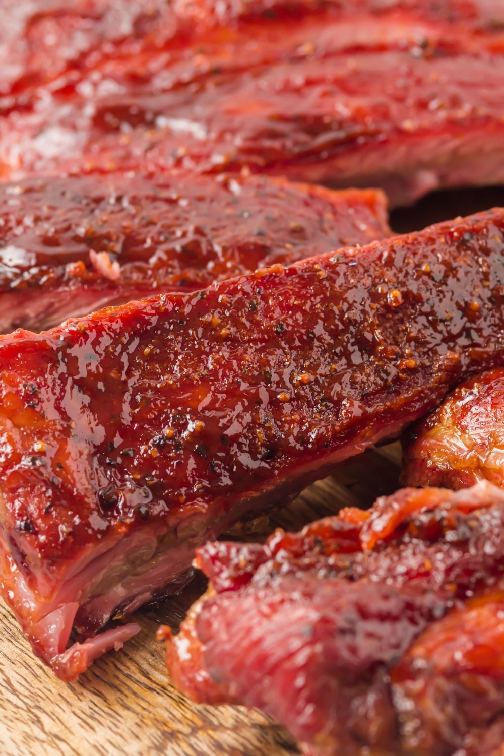 Grilled BBQ Baby Back Ribs cut into strips on a wooden cutting board
