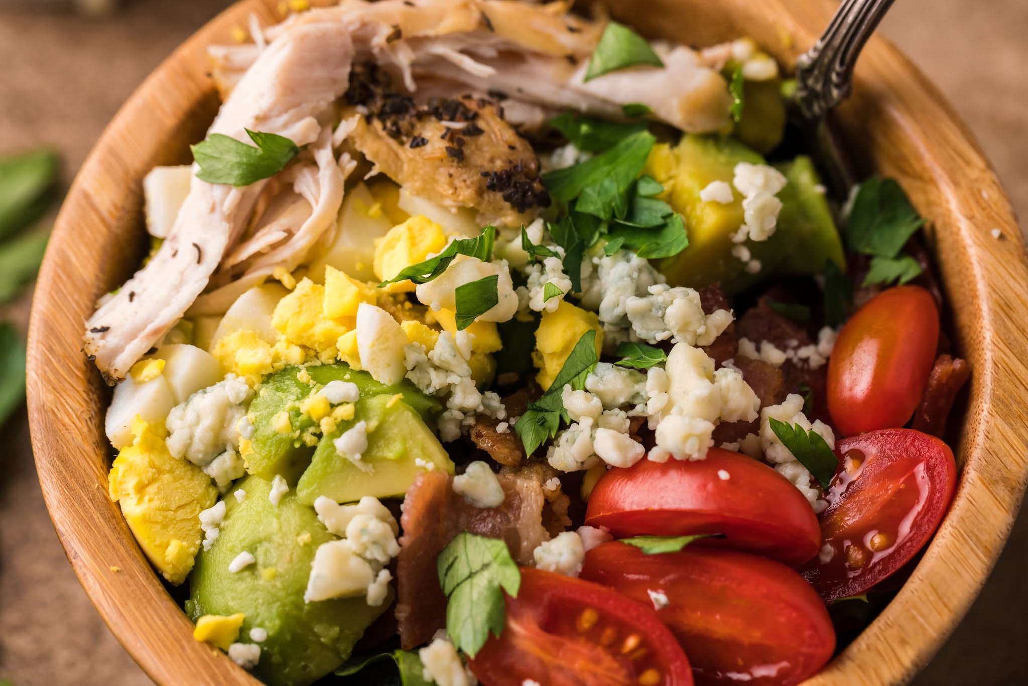 overhead shot of a small wooden bowl of the Copycat Cheesecake Factory Cobb Salad 
