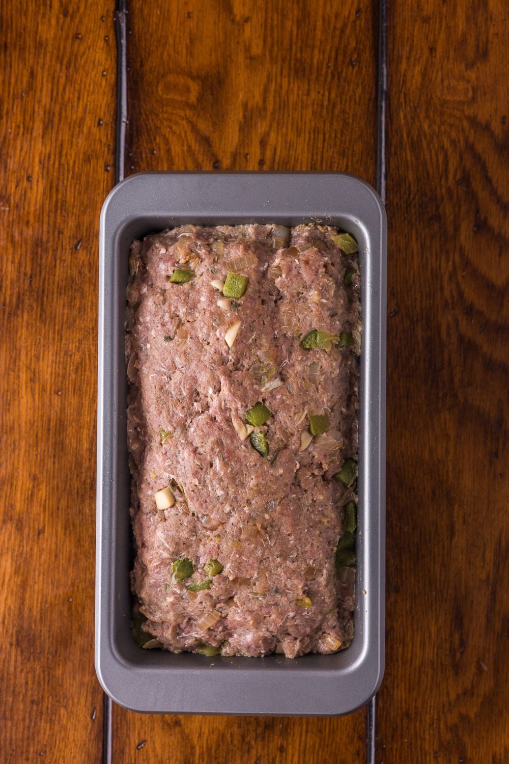 raw Stuffed Philly Cheesesteak Meatloaf in a loaf pan sitting on table