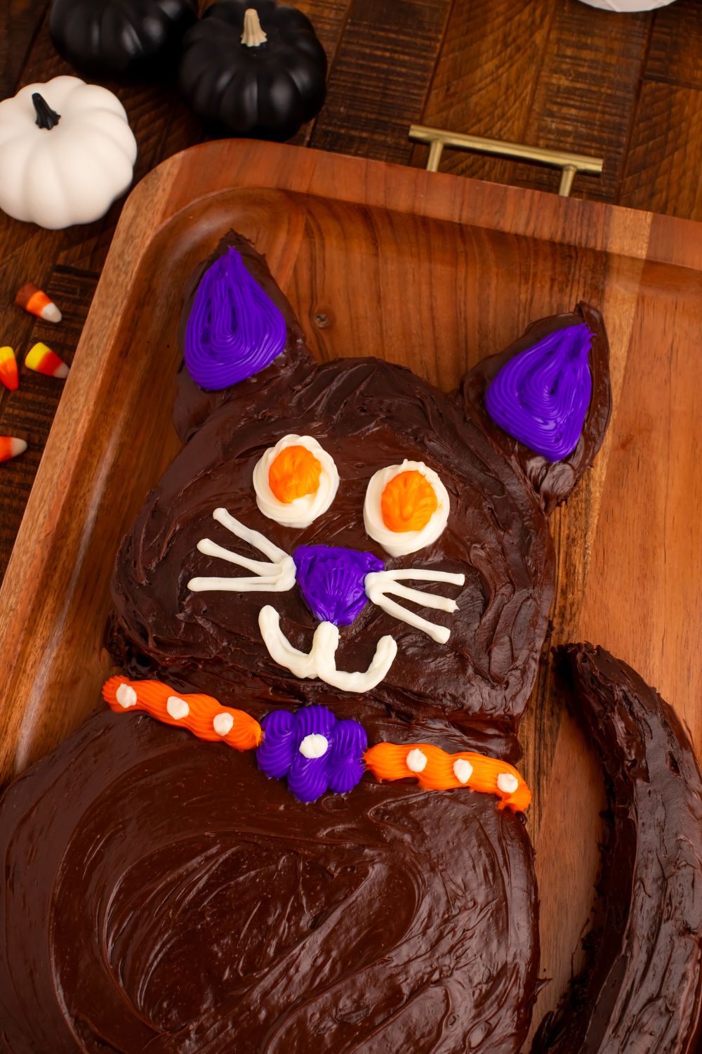 Easy Halloween Black Cat Cut Out Cake sitting on a wooden tray on table to show the Halloween cake