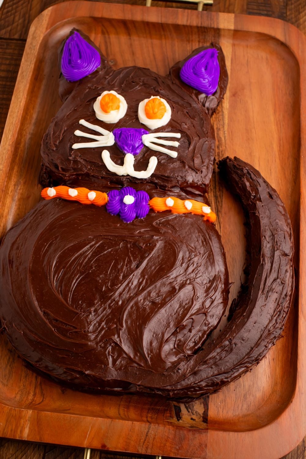 side view of Easy Halloween Black Cat Cut Out Cake on a tray so you can see the whole cat on the table 