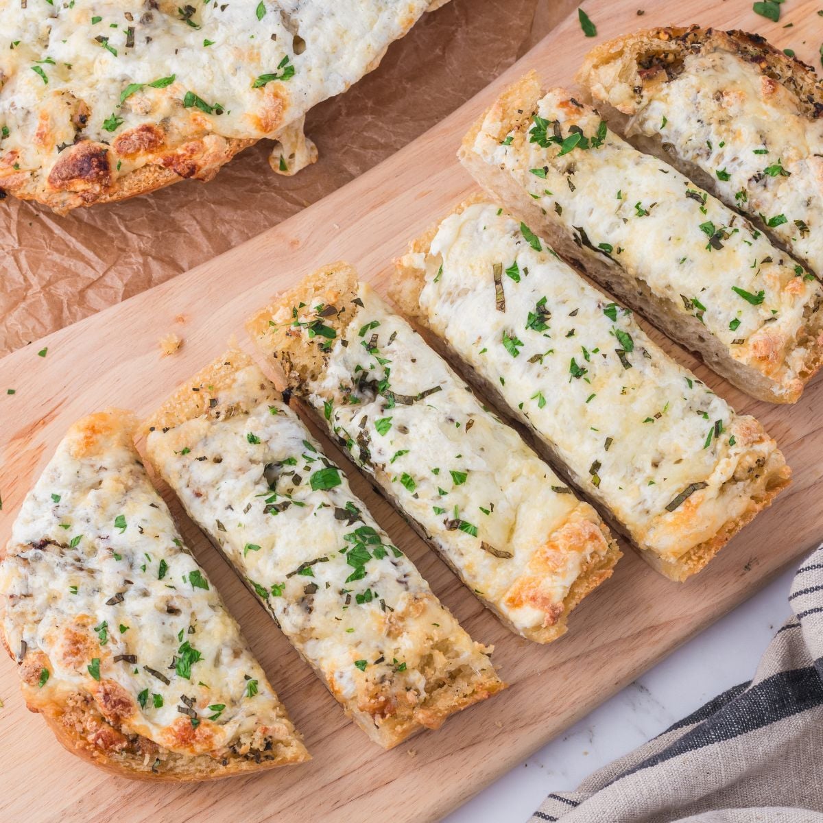 Cheesy Garlic Bread sliced and placed on a cutting board sitting on table
