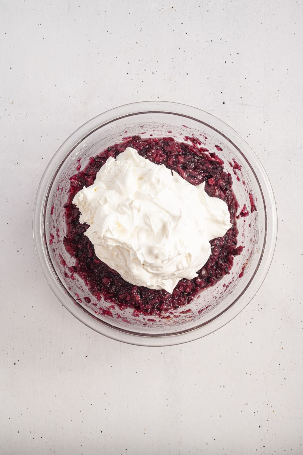 white counter with a cranberry mixture topped with a creamy whipped topping mixture