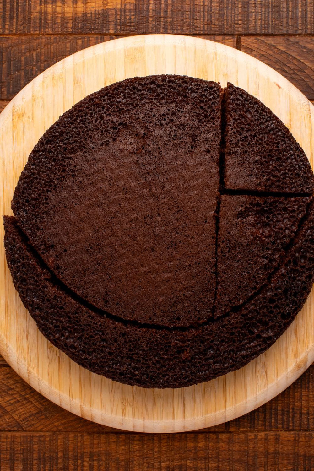 round cake being cut into pieces to shape into a cat 