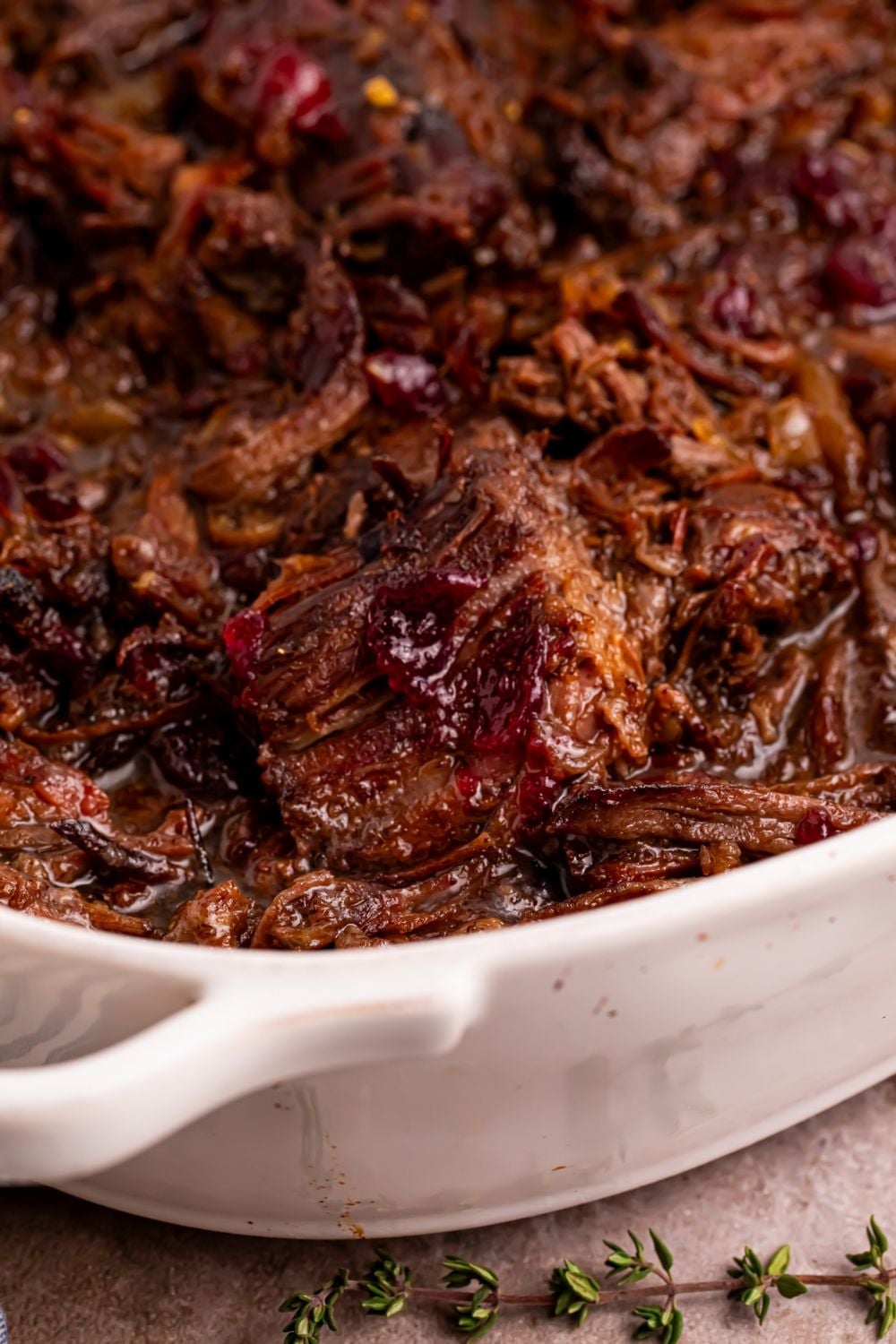 Cranberry Pot Roast shredded and placed in a casserole pan on table