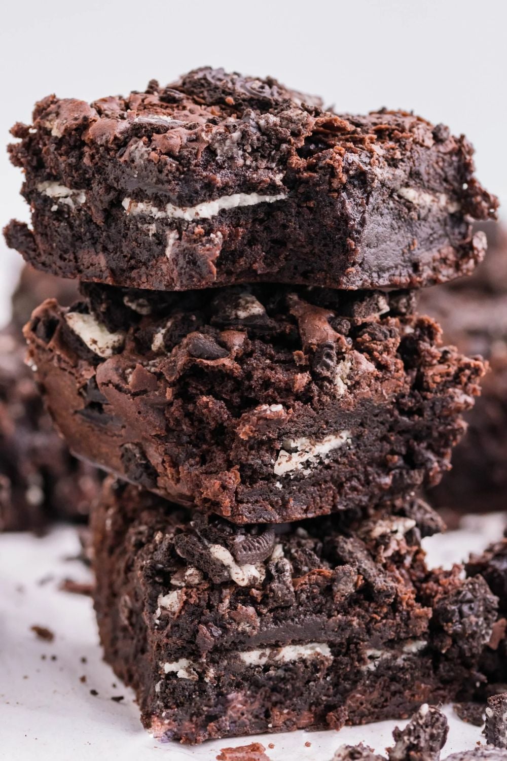 Oreo Stuffed Brownies stacked on table to show the thick brownie layers