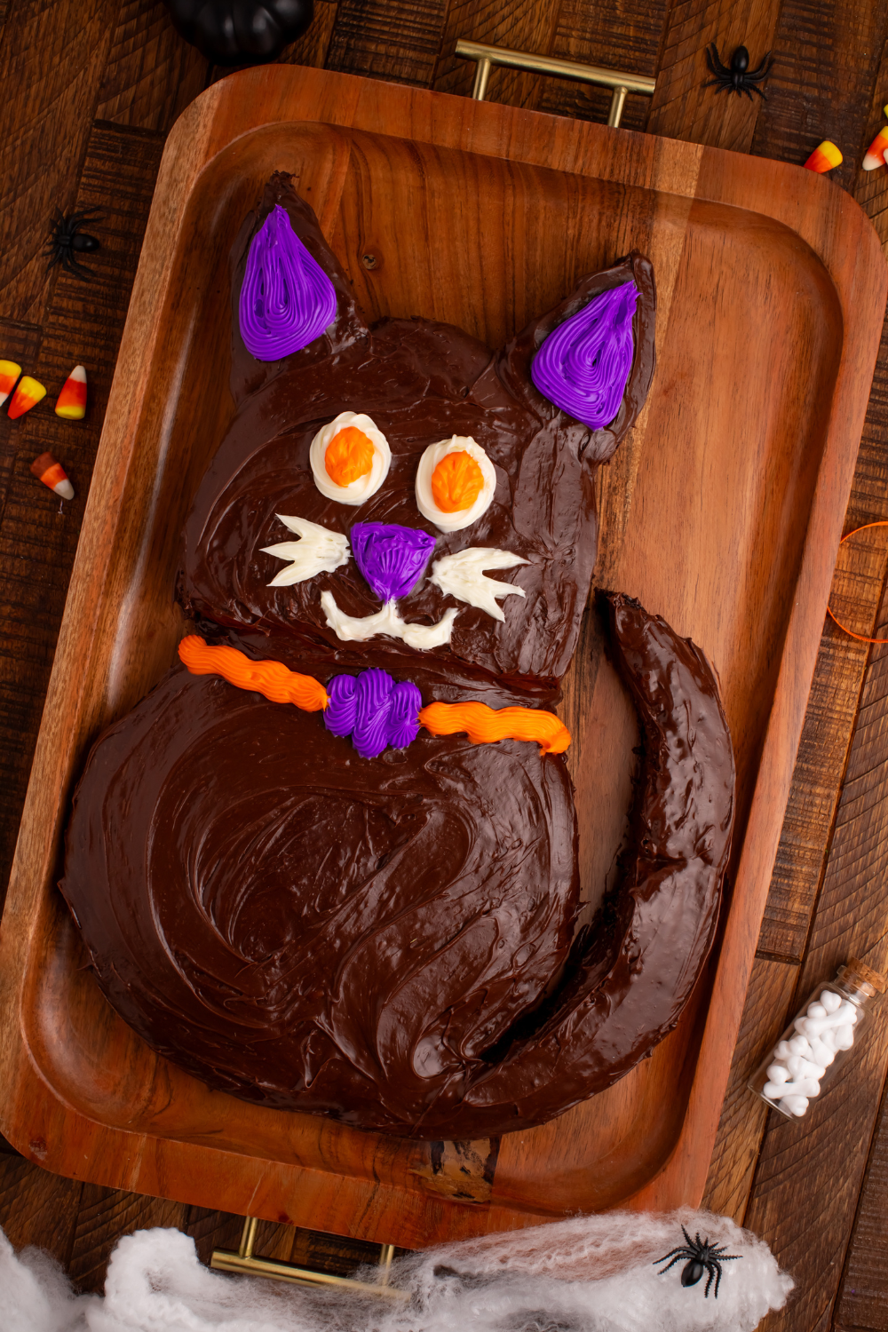 Easy Halloween Black Cat Cut Out Cake on a serving tray on table with some candy corn to the side 