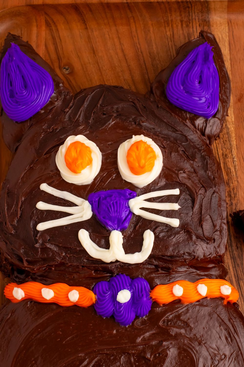 close up of face of cat cake for Halloween on a wooden table tray 