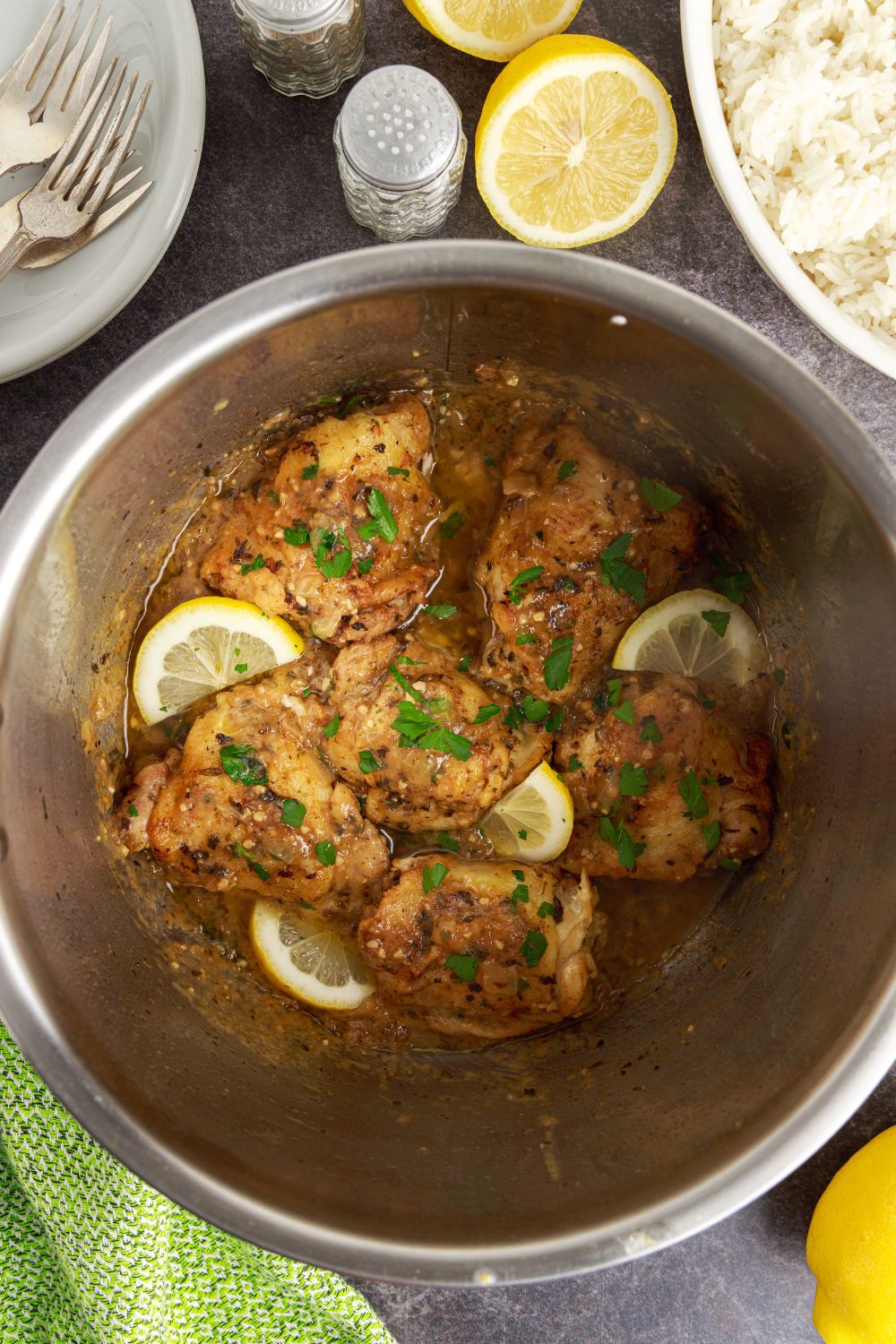 Instant Pot Lemon Butter Chicken with lemons and herbs on top of cooked chicken in instant pot