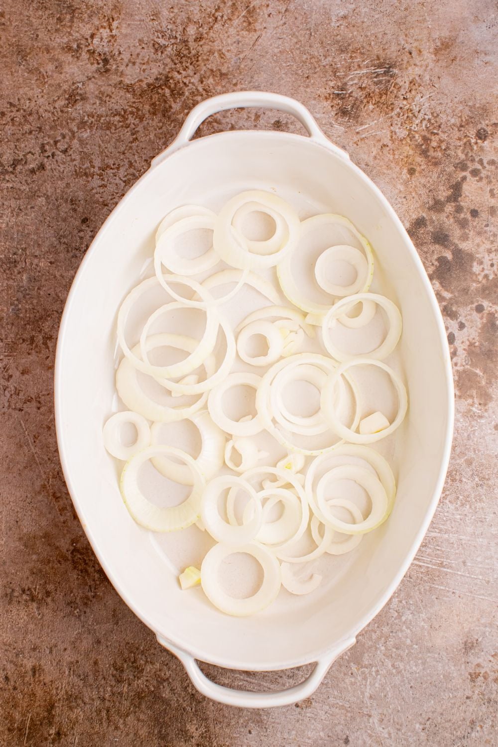 sliced onions in casserole dish on table
