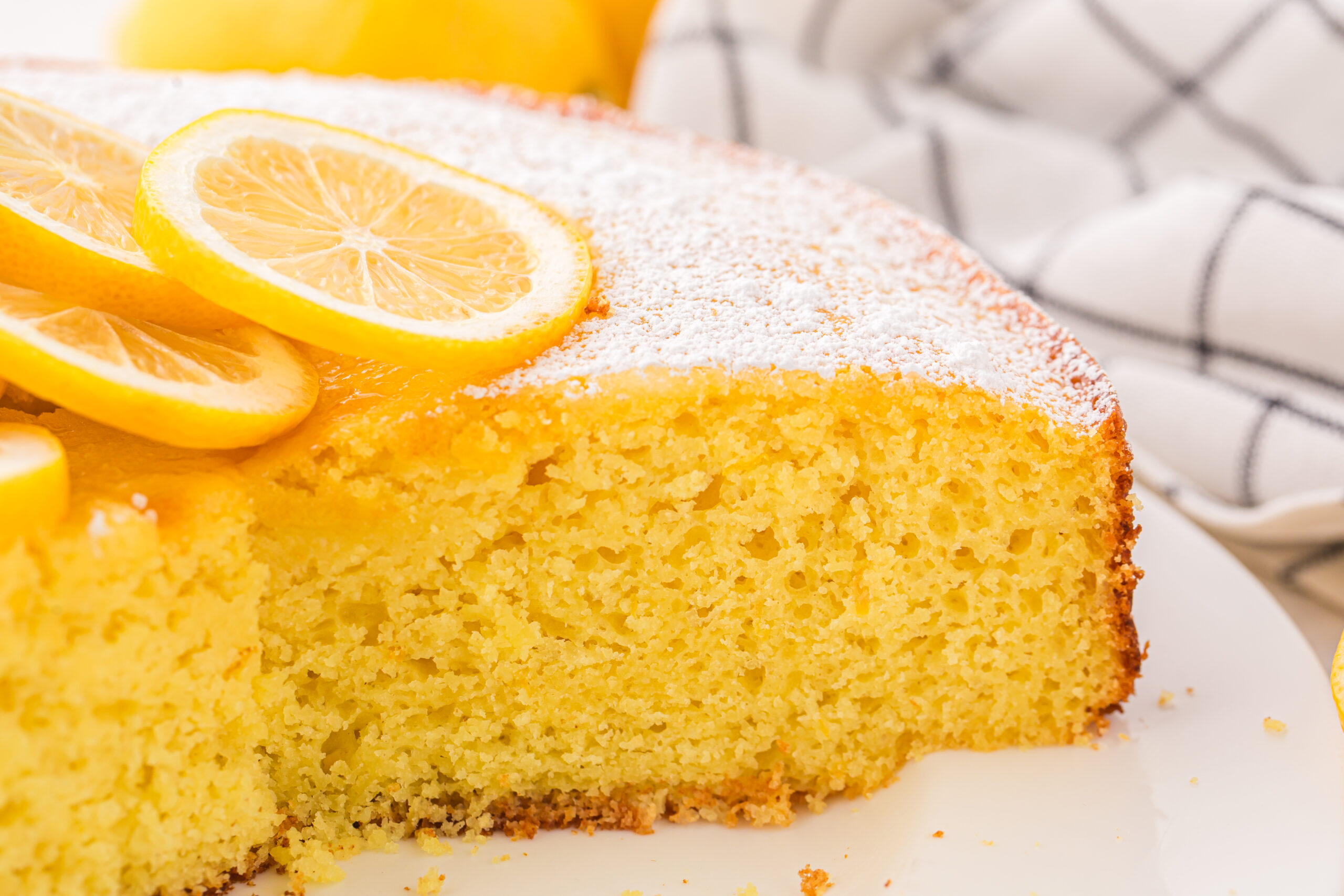 sliced Italian Lemon Ricotta Cake on a plate with a couple slices missing 