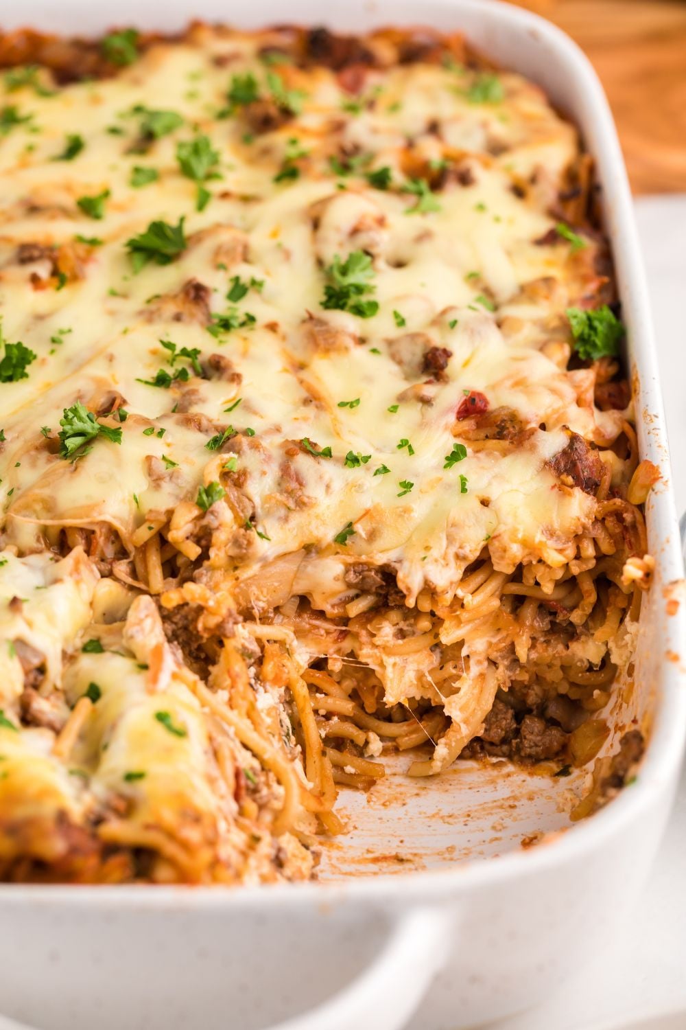 Million Dollar Spaghetti Casserole in a pan with some of the casserole removed from pan
