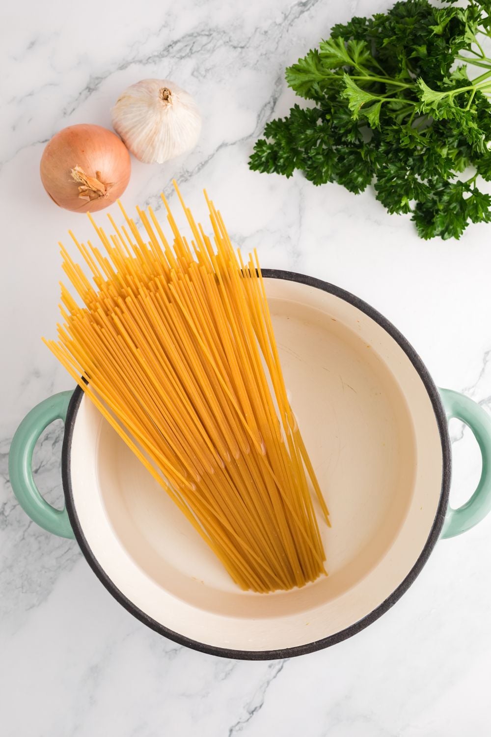 pot with water with dry pasta in it on table