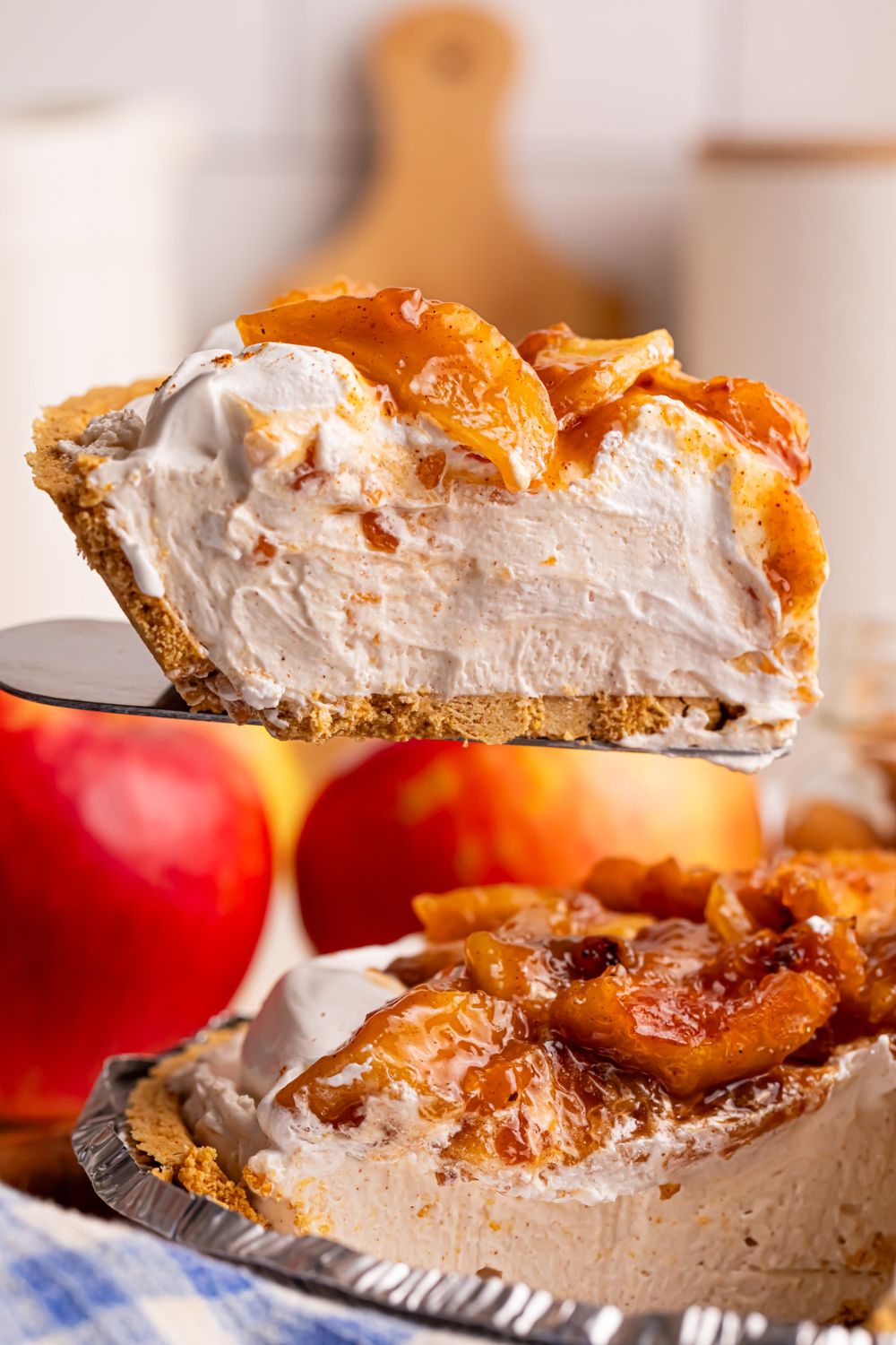 spatula with No Bake Apple Cheesecake pie slice on it above the pie plate