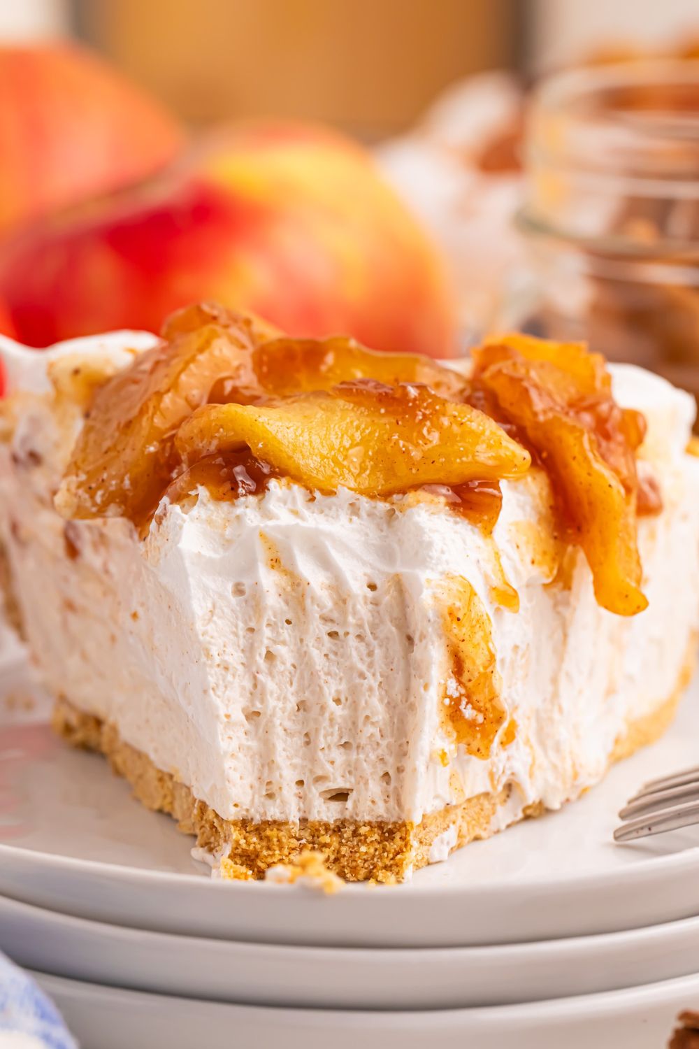 slice of No Bake Apple Cheesecake pie with a fork bite taken out of the cake to show how creamy it is