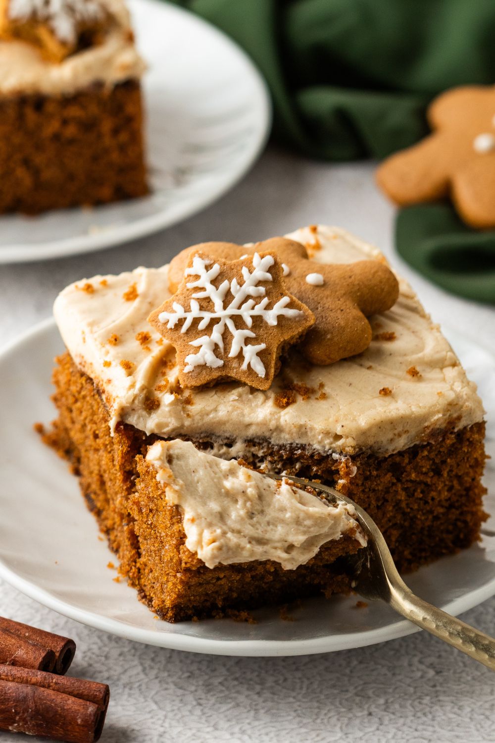 slice of Gingerbread Cake with Cream Cheese Frosting on pan with a fork poking into cake for taking a bite out of it