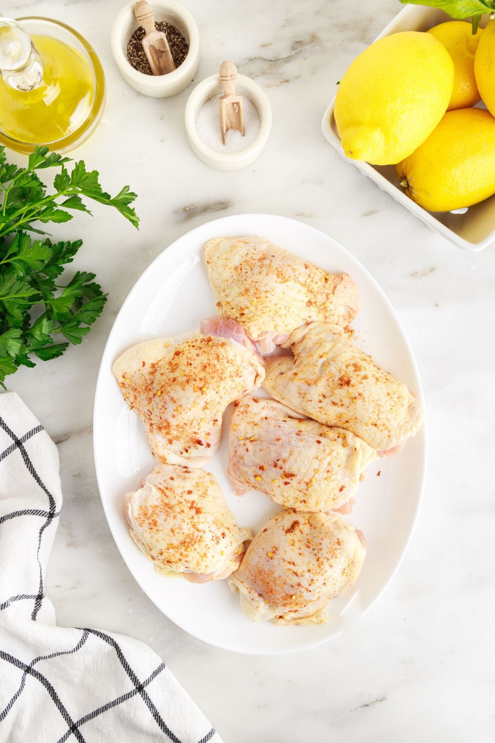raw chicken on plates with parsley and other ingredients around the table