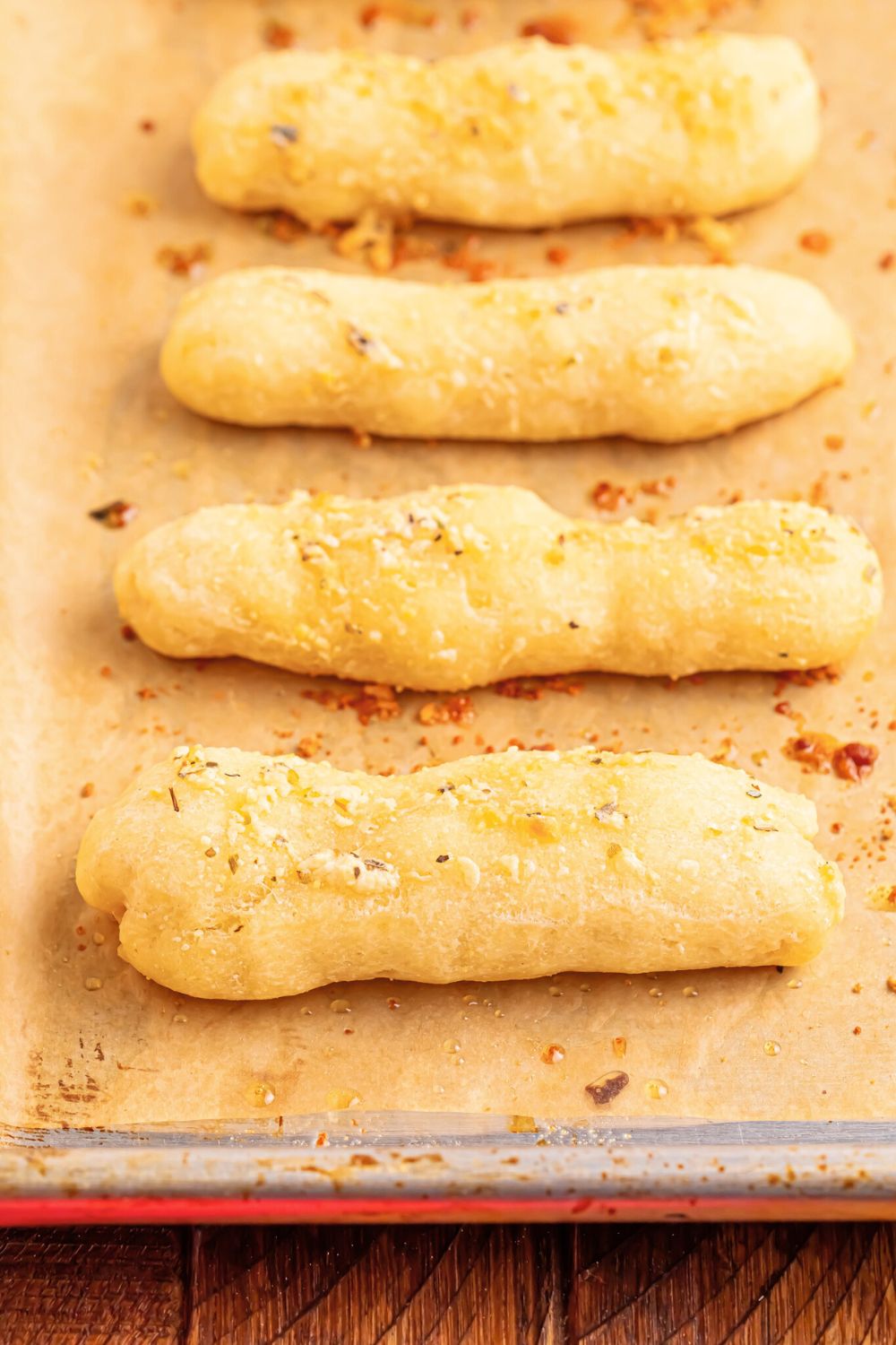 baked 2 Ingredient Garlic Parmesan Breadsticks on a baking tray with parchment paper under