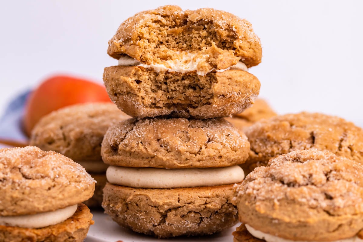 Pile of Apple Cider Whoopie Pies stacked with a bite missing from the top one