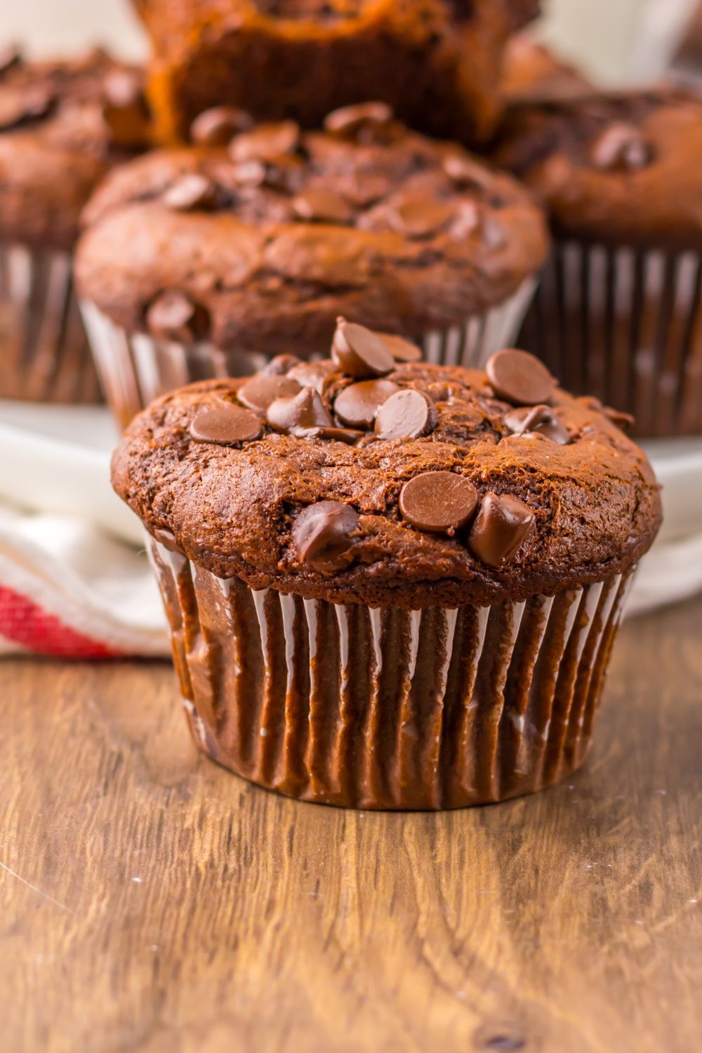 close up of Costco Double Chocolate Muffins on table with more in a tray behind it