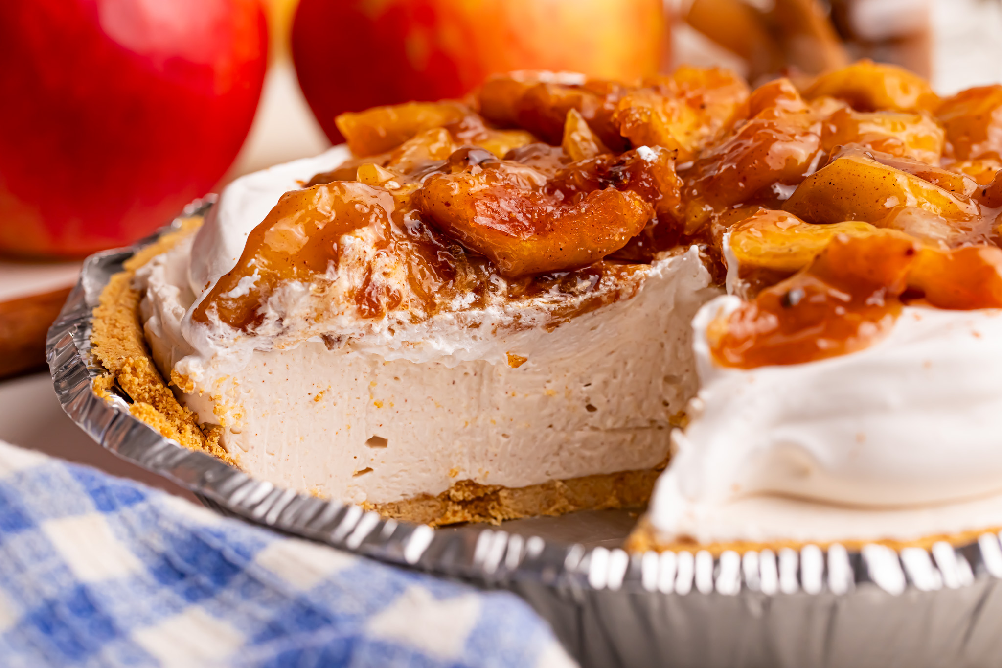 side view of the No Bake Apple Cheesecake pie in the pie plate with a piece missing