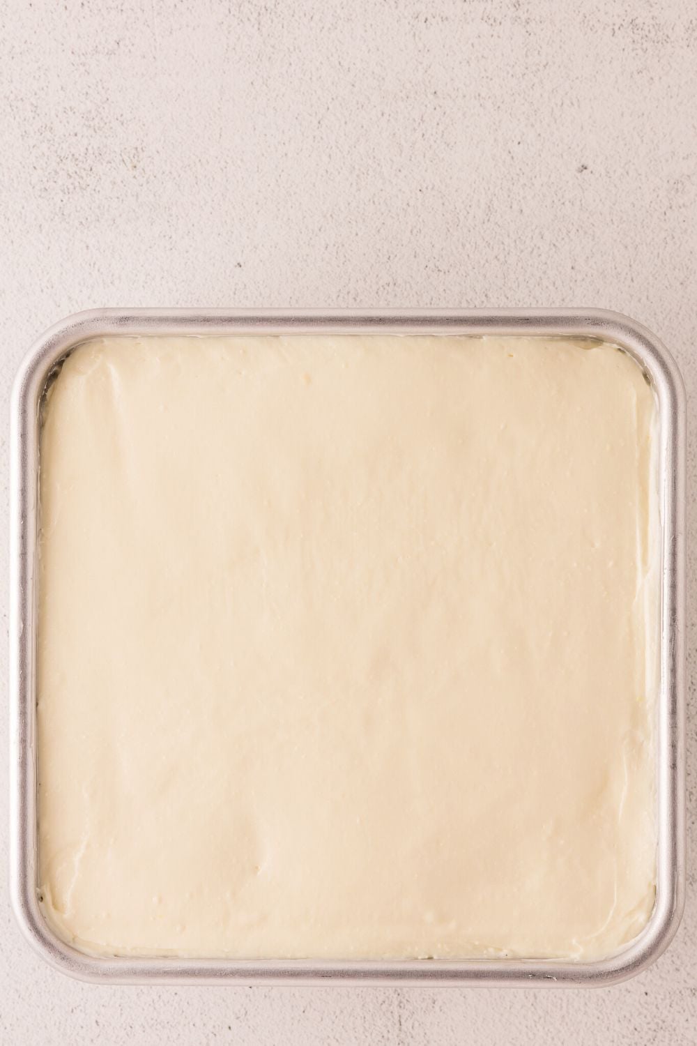 No Bake Banana Pudding Cheesecake Bar batter in a pan on table