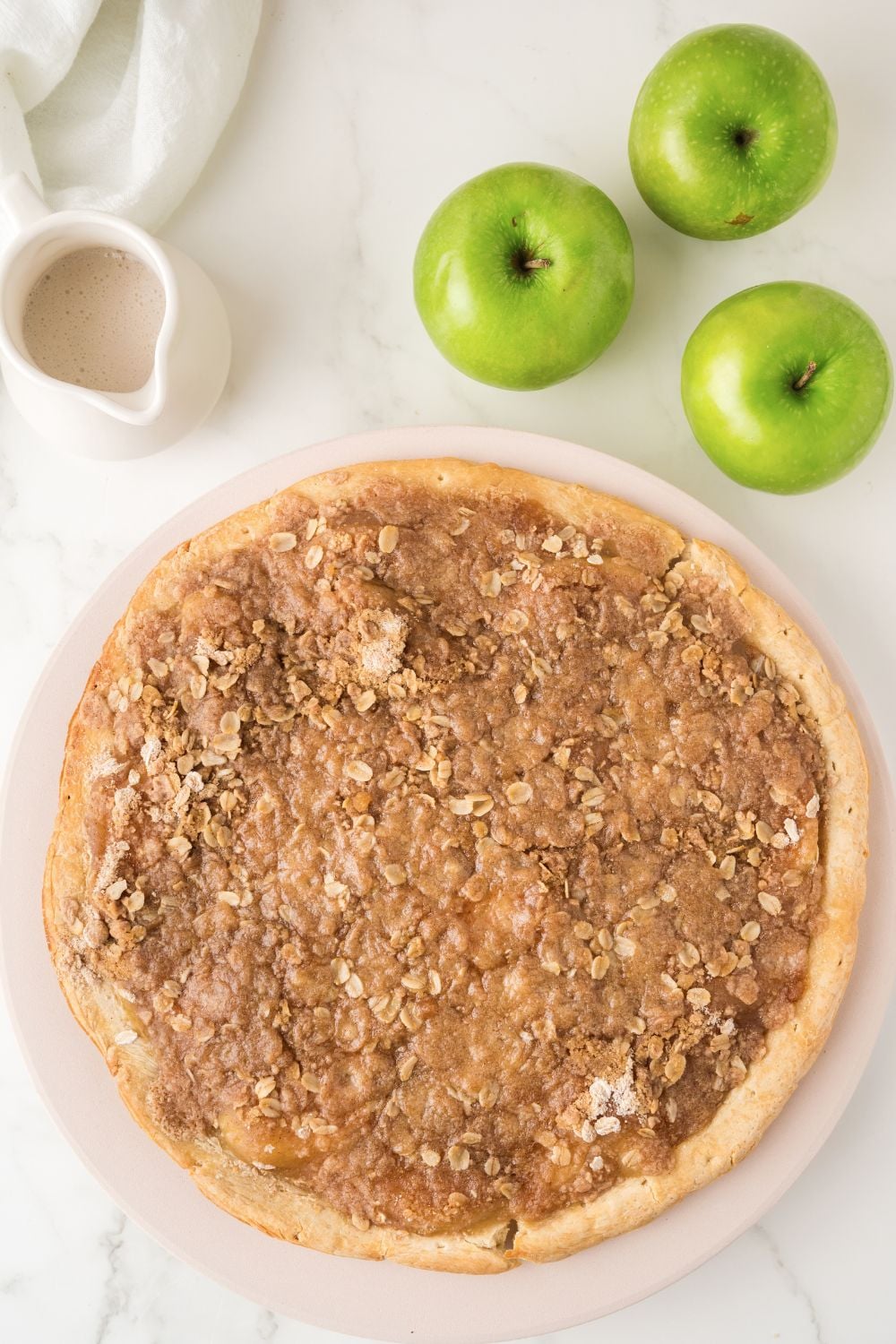 Apple Pie Pizza on table with green apples to side
