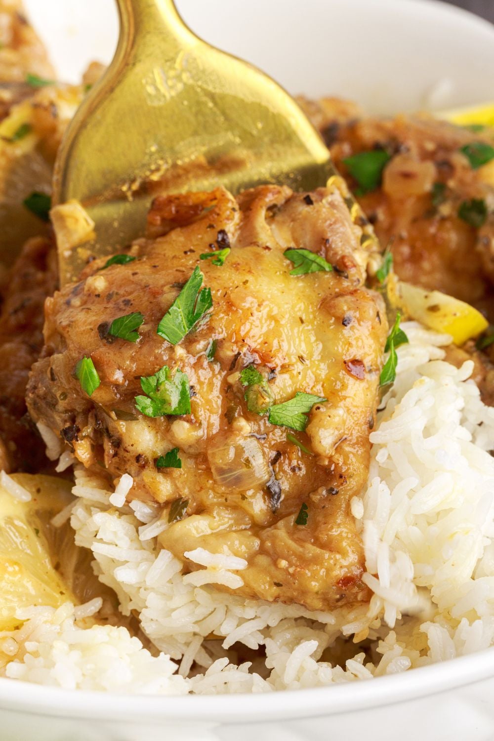 Instant Pot Lemon Butter Chicken and rice on plate with a fork poking into the chicken