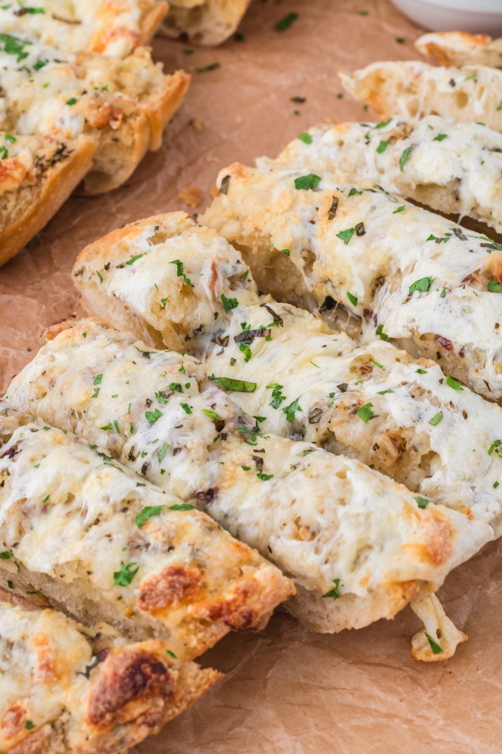 Cheesy Garlic Bread sliced into strips on cutting board