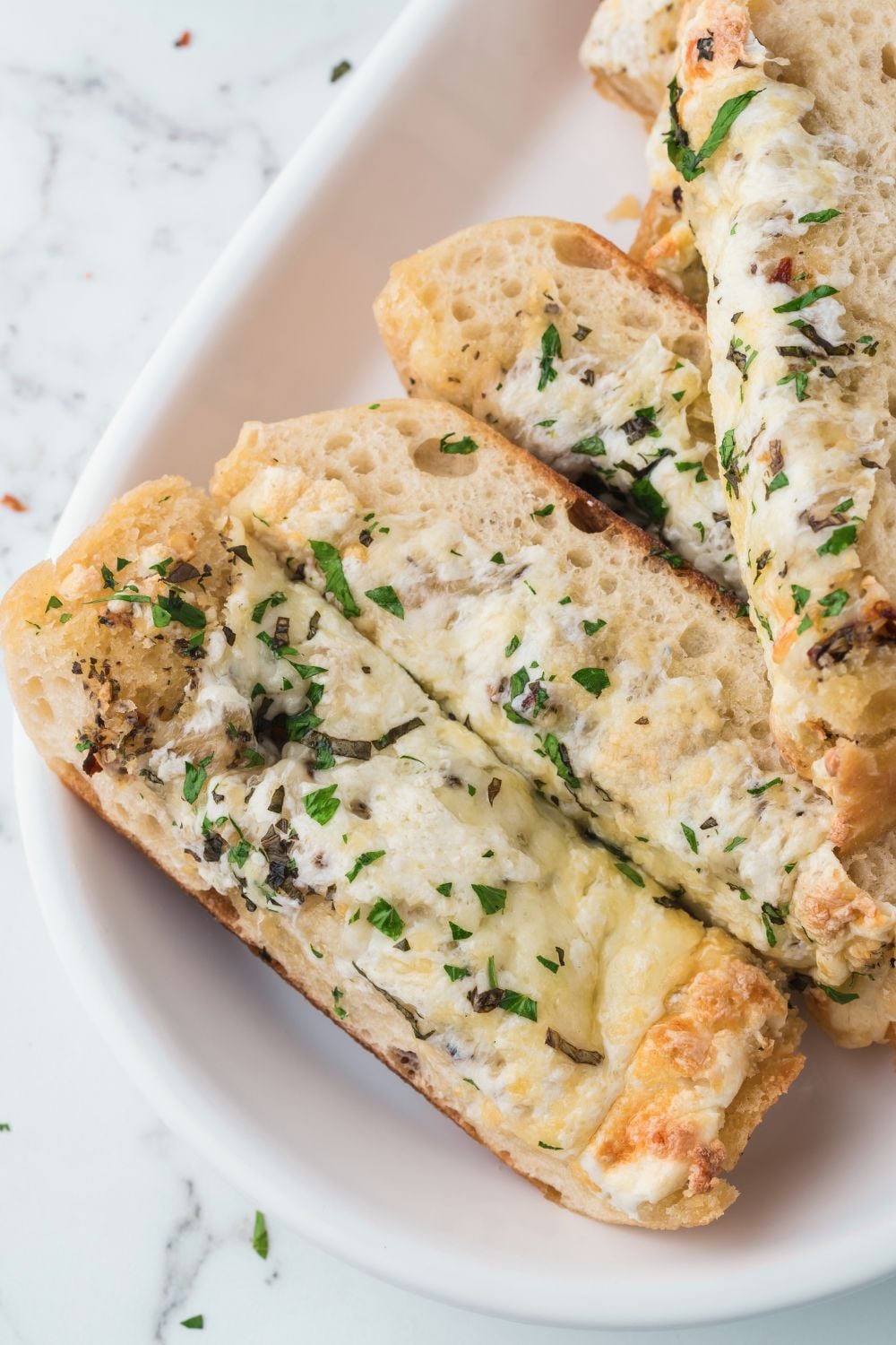 plate with Cheesy Garlic Bread sliced on it
