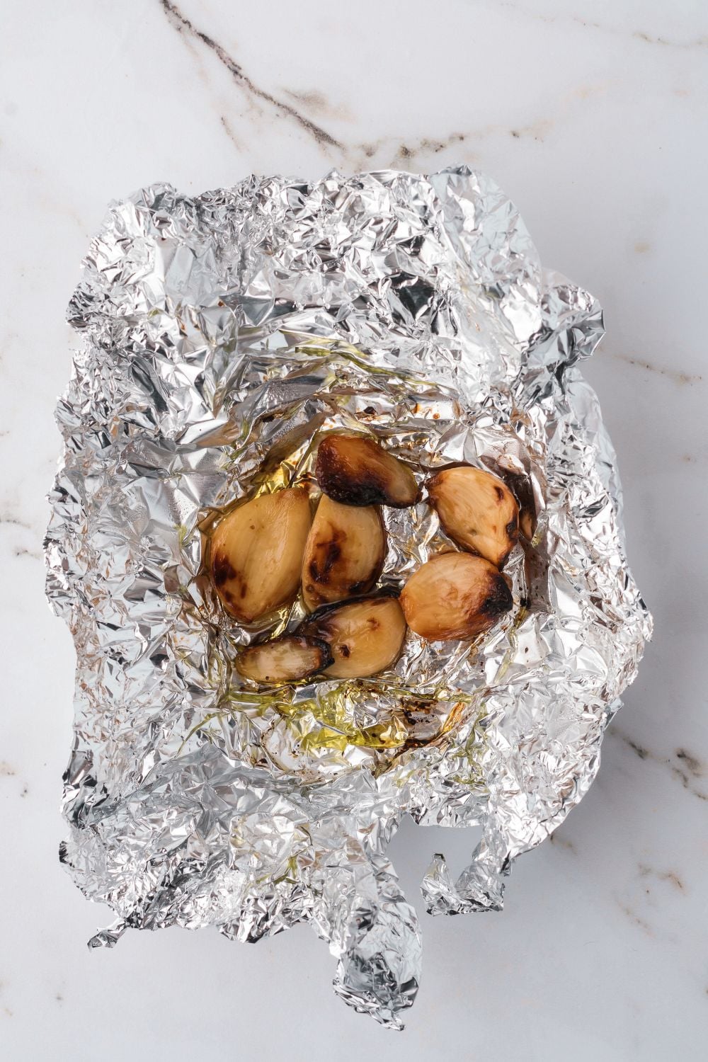 roasted garlic in foil sitting on table