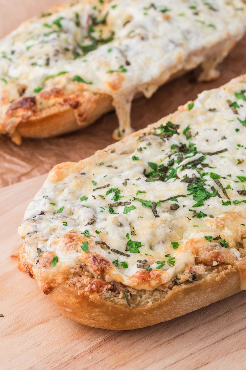 side view of French bread Cheesy Garlic Bread on tray on table