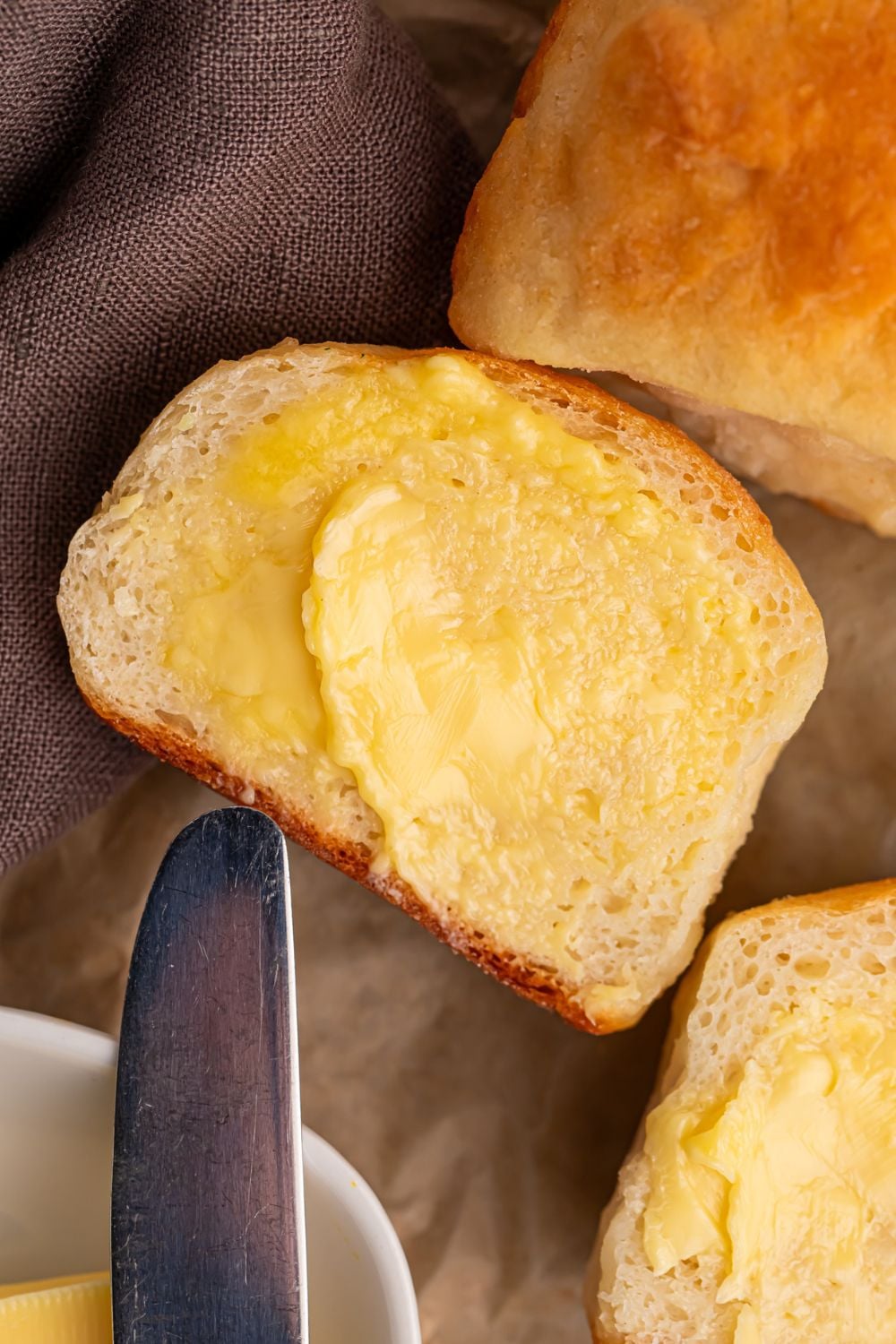 2 Ingredient Dinner Rolls on table that are spread with butter