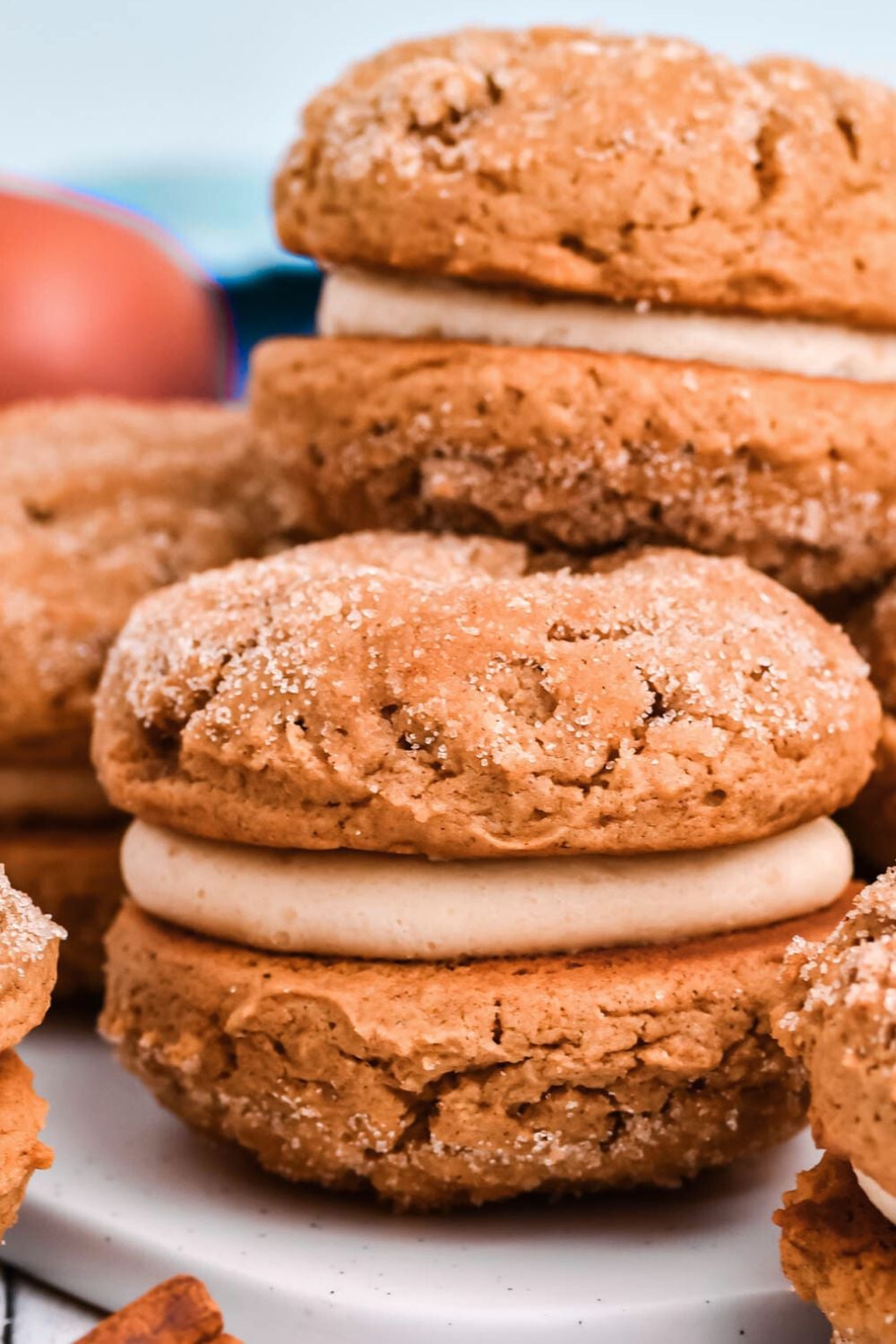 Apple Cider Whoopie Pies stacked on the table with apples behind it
